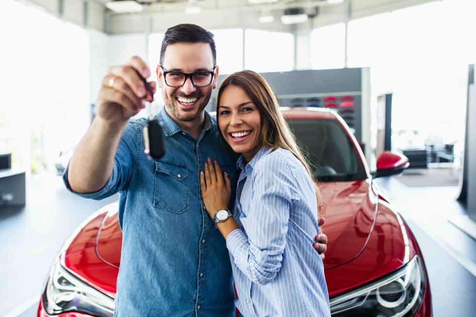 couple holding keys to new car